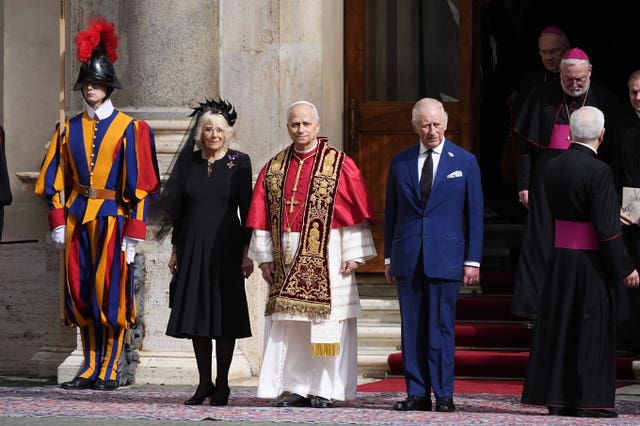 The royal couple stand next to the Pope, flanked by Swiss Guards