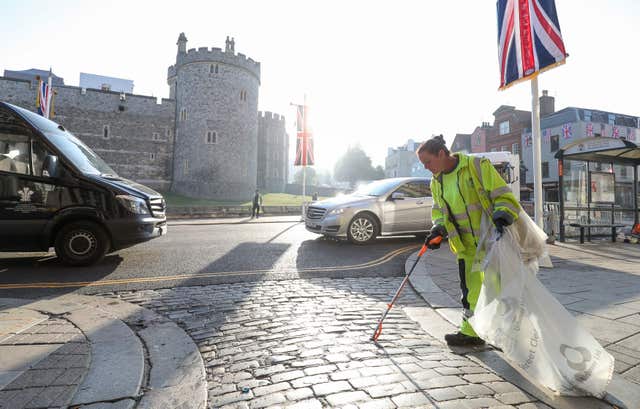 A council worker collecting rubbish on the High Street in Windsor (Andrew Matthews/PA)