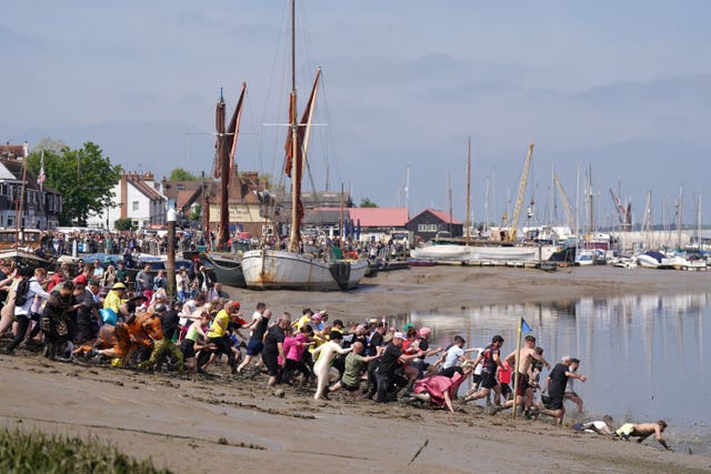 Competitors take part in the annual Maldon Mud Race, a charity event to race across the bed of the River Blackwater in Maldon, Essex