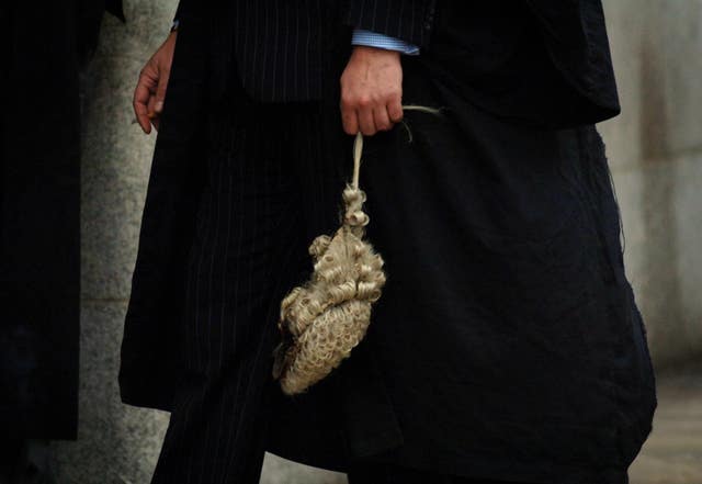 A barrister holding a legal wig by his side (Clara Molden/PA)
