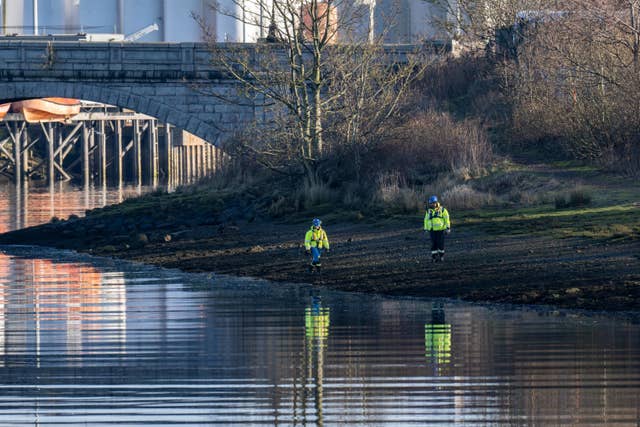 Police officers on riverbank