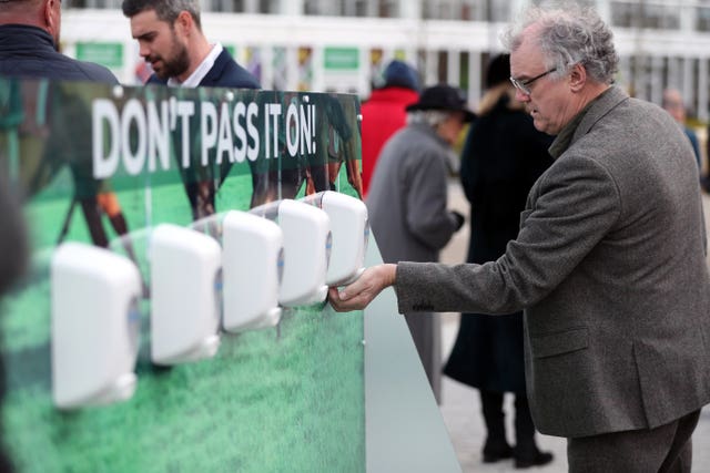 Racegoers use sanitiser to keep their hands clean at Cheltenham Festival 