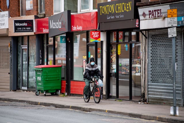 A man wearing PPE cycles in the Spinney Halls area of Leicester 