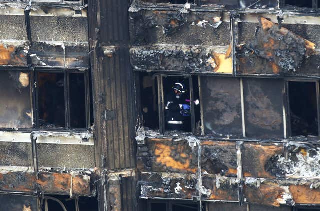 Fire service personnel survey the damage to Grenfell Tower 