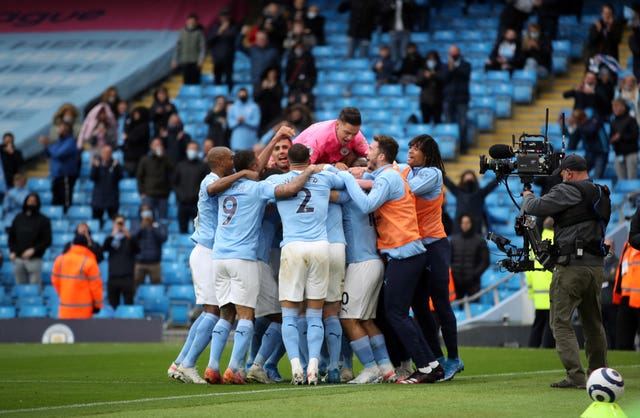 Manchester City's Sergio Aguero is mobbed by all of his team-mates after scoring
