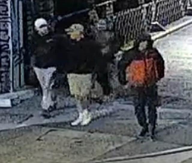 CCTV image of four people walking down a street