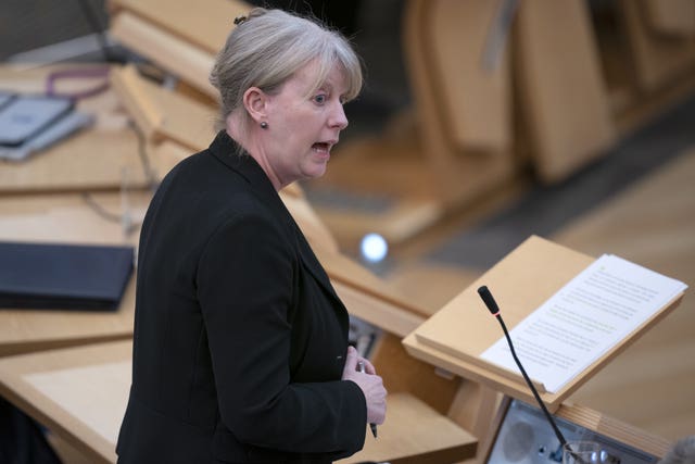 Shona Robison standing while speaking in Parliament