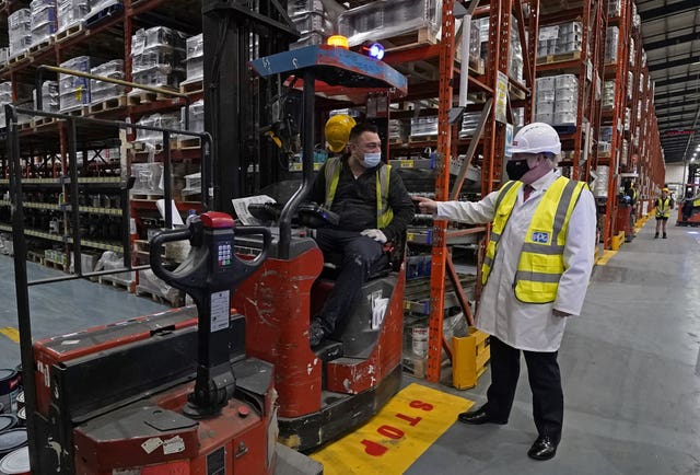 Boris Johnson, right, talks to a member of staff during his visit to Johnstone’s Paints in Batley, West Yorkshire 