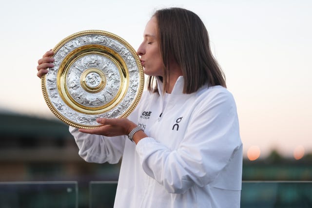 Iga Swiatek kisses a replica trophy