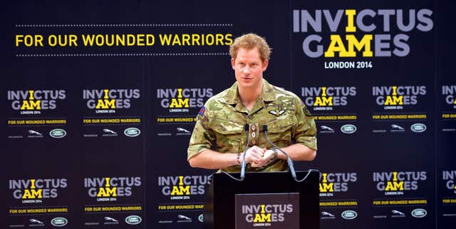 Harry in military fatigues speaking from a podium as he launched the Invictus Games in London in 2014