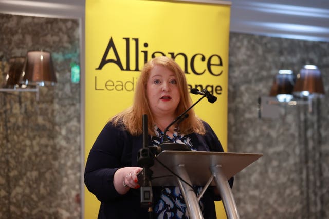 Alliance leader Naomi Long speaking in front of a yellow Alliance banner during the party’s General Election manifesto launch at the Ivanhoe Hotel in Belfast 