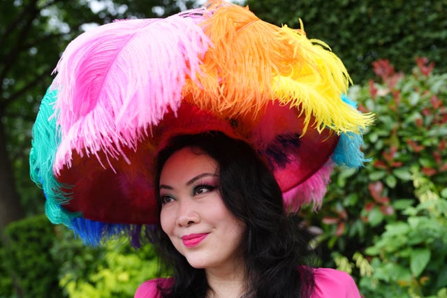 A woman sports a multi-coloured feather-like hat