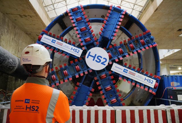 A HS2 worker stands in front of a tunnel boring machine