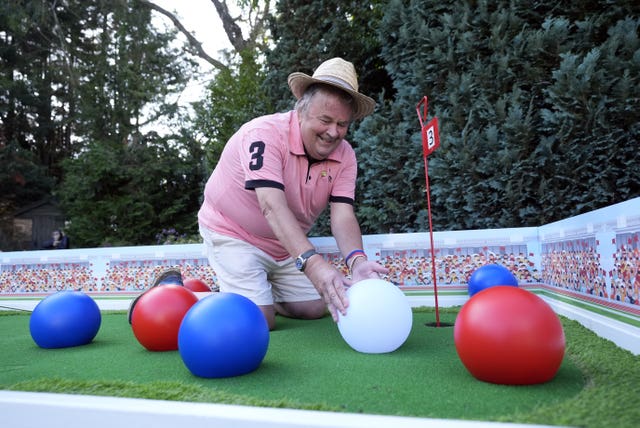 David Lawrence adjusting the layout of his hole based on the sport of boccia using large red, white and blue balls