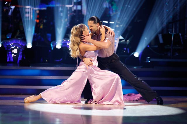 A woman and a man embrace on the dancefloor