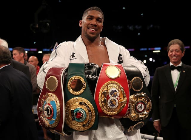 Anthony Joshua celebrates with his belts