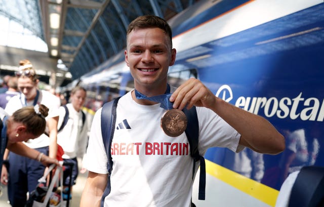 Richardson shows his medal to the camera