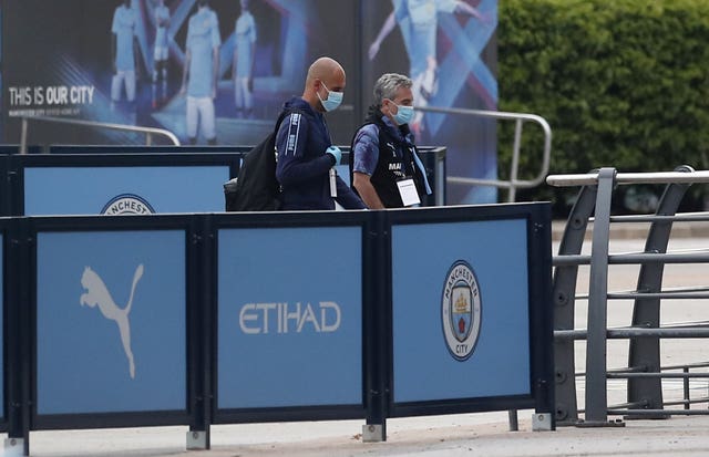 Pep Guardiola arrives at the Etihad Stadium in a mask as football resumed after the coronavirus pandemic 