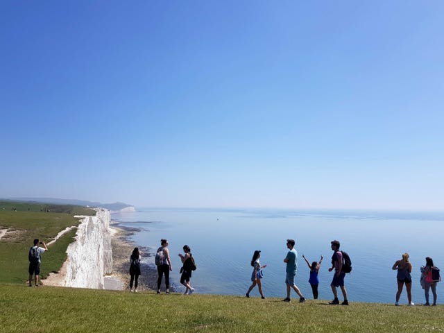 People admire the view of the Seven Sisters Cliffs in Sussex through a heat haze (Catherine Wylie/PA)