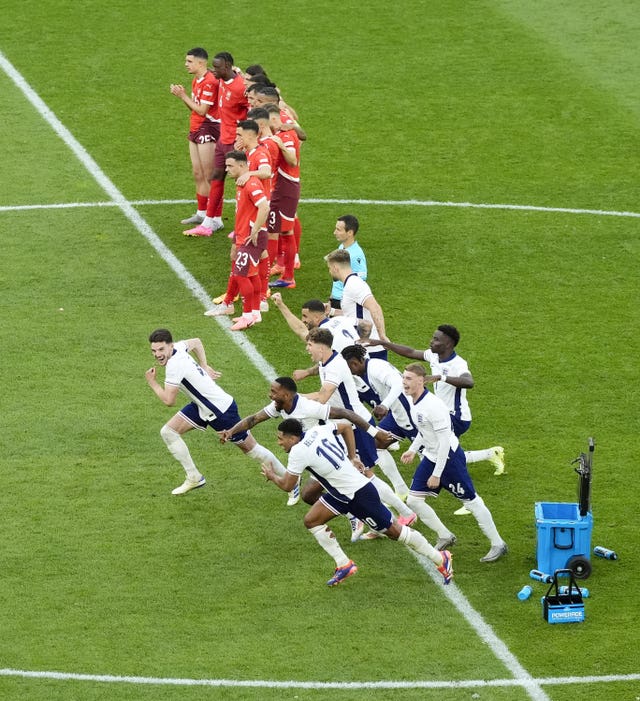 England players celebrate after Trent Alexander-Arnold scores the winning penalty against Switzerland