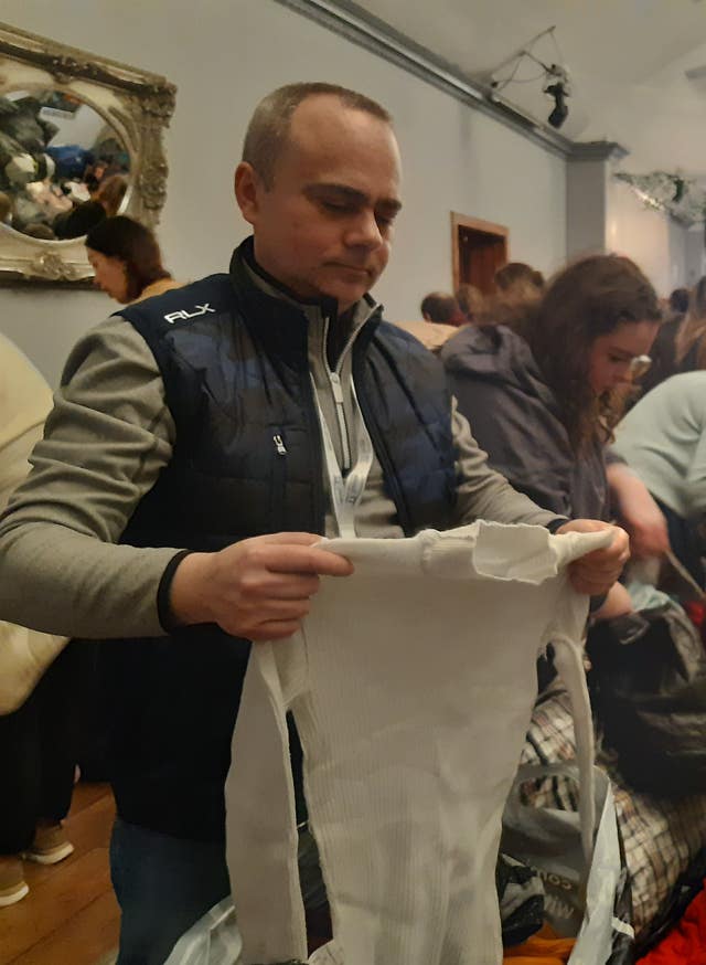 Krzysztof Gonder joins volunteers to sift through donations 
