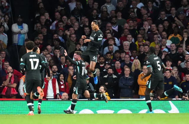 Virgil van Dijk leaps in the air to celebrate with his Liverpool team-mates