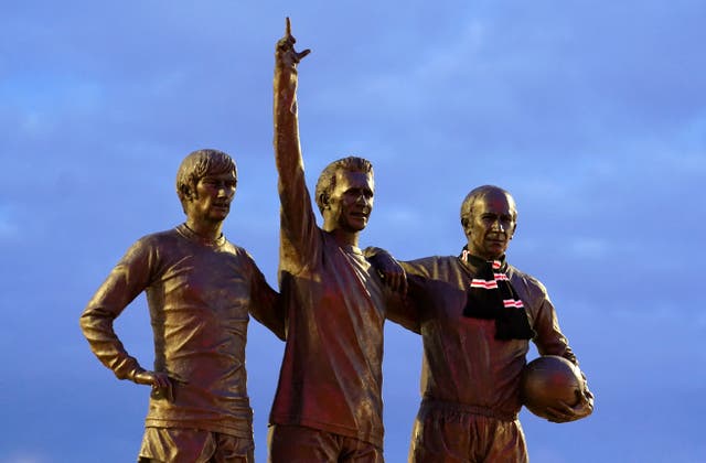 A scarf is placed around the neck of Sir Bobby Charlton as tributes are laid in his memory