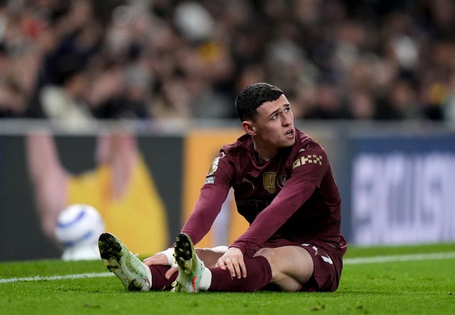 Manchester City forward Phil Foden sits on the floor legs outstretched