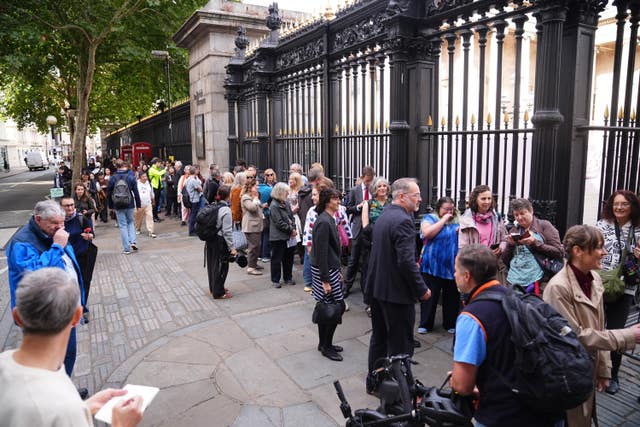 People wait in line outside the British Museum in central London as the Bayeux Tapestry exhibition opens to members of the public