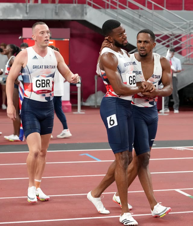 Nethaneel Mitchell-Blake, centre, embraces CJ Ujah after finishing second in the 4 x 100m relay in Tokyo as team-mate Richard Kilty, left, looks on