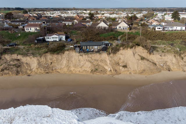 Former soldier Lance Martin, 63, stands in the back garden of his home in Hemsby, Norfolk, where his back door is now no more than six metres from the cliff edge after more land has been lost to the sea in the past few days 