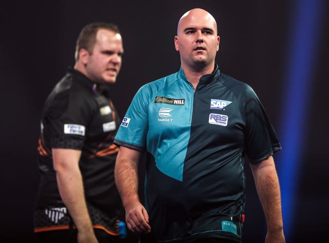 Rob Cross (right) walks off stage after losing to Dirk Van Duijvenbode (left) in the PDC World Championship at Alexandra Palace