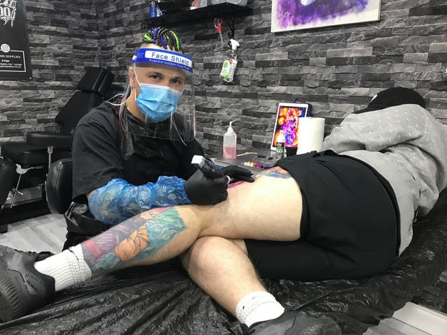Nico Pantu tattooing a customer at Grimm Tattoo Studio in Leeds as it reopens to customers following the easing of lockdown restrictions in England