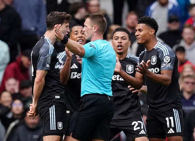 Aston Villa players confront referee Thomas Bramall after he controversially disallowed Morgan Rogers' goal at Manchester United