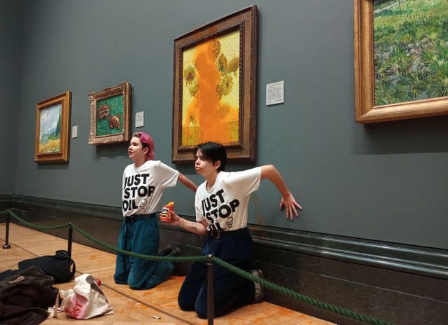 Protesters kneeling in front of painting