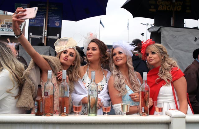 Racegoers take a selfie amid the rain (Peter Byrne/PA)