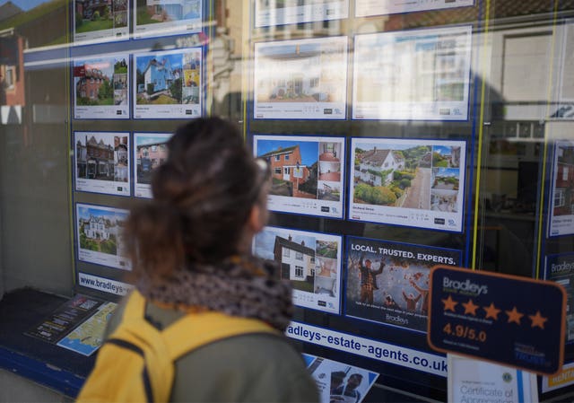 Woman looking in an estate agent window