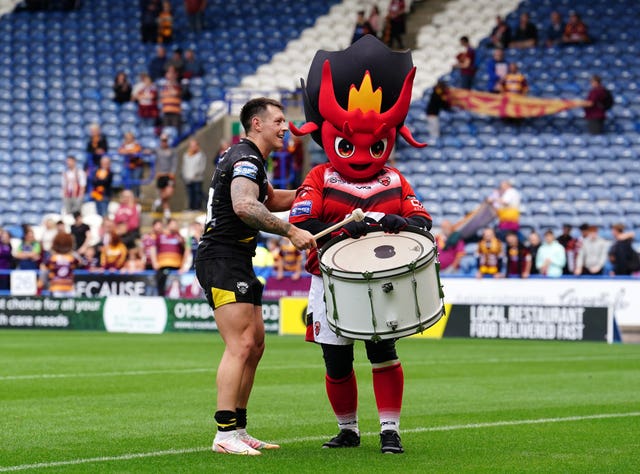 Salford’s Deon Cross celebrates with mascot Diablo the Devil after victory over Huddersfield