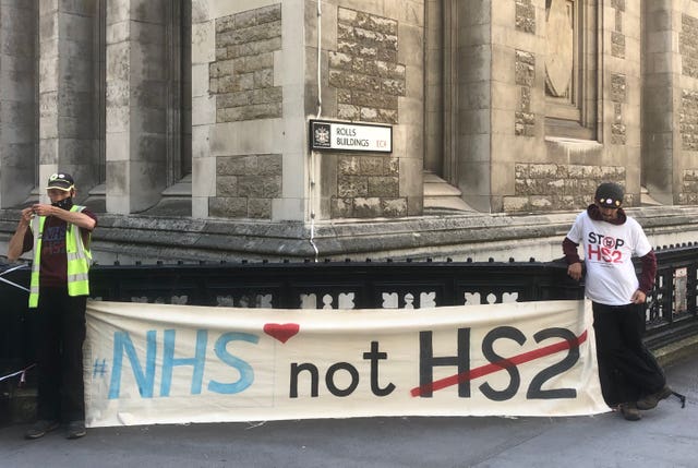 Brothers Terry (left) and Paul Sandison spell out their message outside the High Court in London 