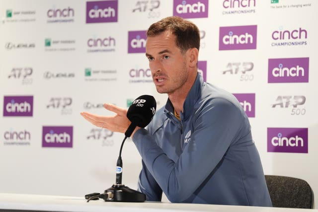 Andy Murray speaks and gestures with his hand during a press conference
