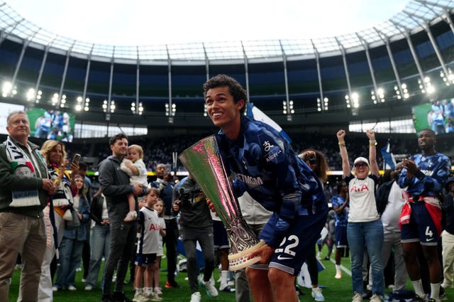 Brennan Johnson with the Europa League trophy on the pitch after the defeat to Brighton