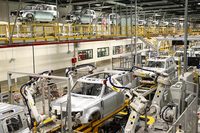 Machines making cars inside a factory