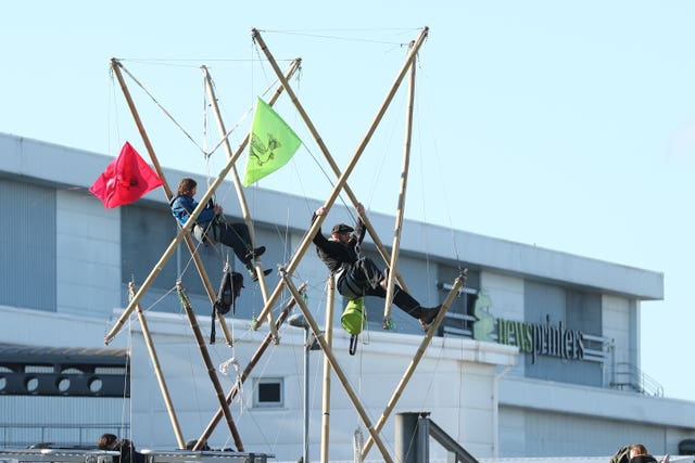 Two protesters use bamboo lock-ons to block the road outside the Newsprinters printing works at Broxbourne, Hertfordshire