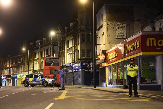 A police forensics officer works at the scene in Streatham High Road, south London after a man was shot dead by armed officers