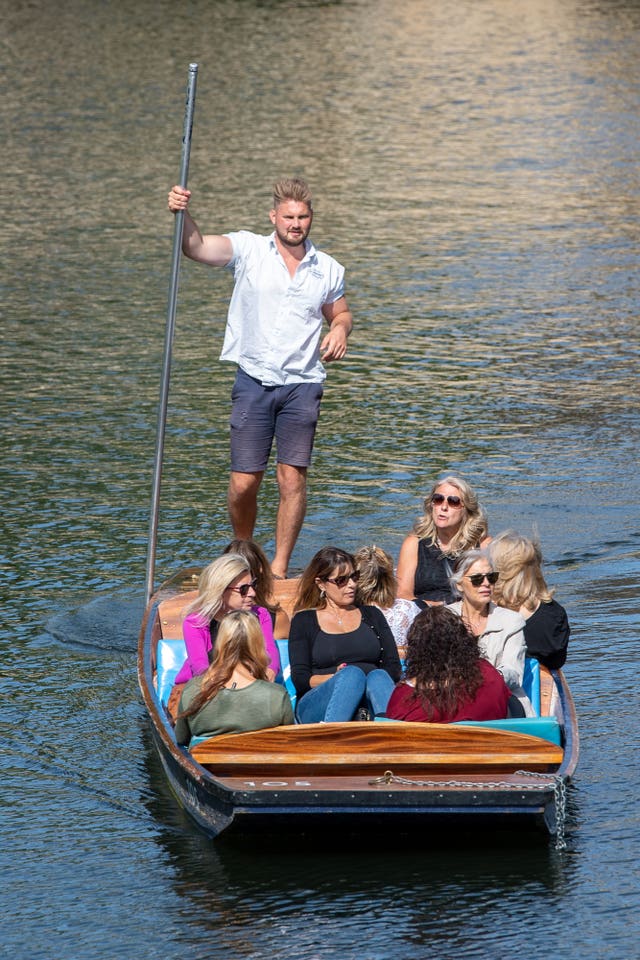 People enjoy a punt trip along the River Cam in Cambridge