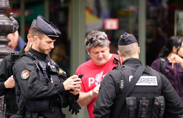 A Liverpool fan receives help from local police in Paris ahead of Saturday’s Uefa Champions League final at the Stade de France
