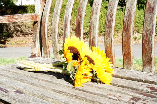 Flowers left on a bench near the police cordon 