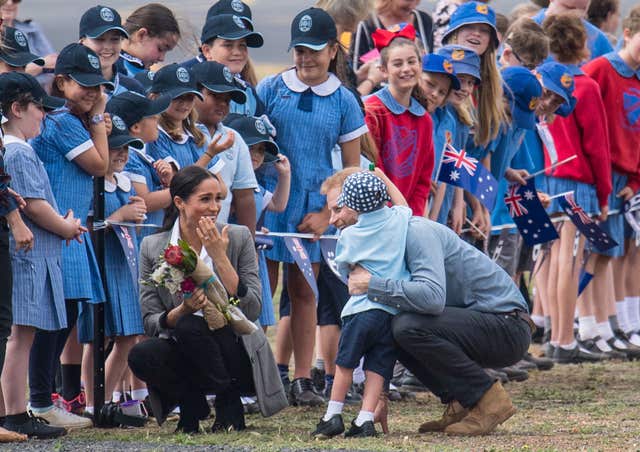 Harry and Meghan greet a youngster in Australia