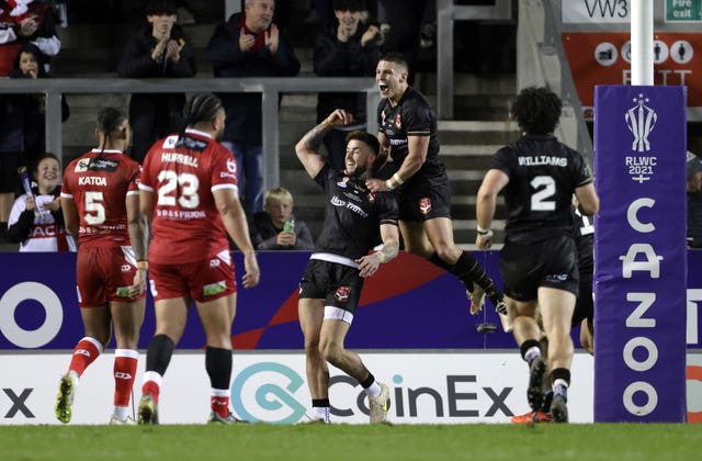 Kyle Evans, centre, celebrates the opening try of the game 