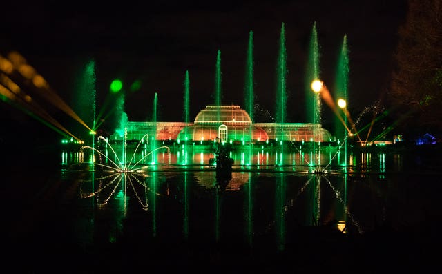 A view of the Palm House Grand Finale, which includes festive projections falling on a giant screen of water in the lake, during a preview for Christmas at Kew at the Royal Botanic Gardens in Kew, London